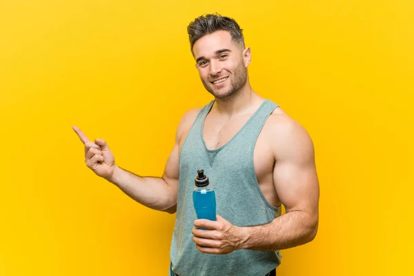 Uomo Caucasico Possesso Una Bevanda Energetica Sorridente Allegramente Indicando Con — Foto Stock