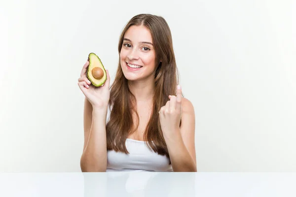 Joven Mujer Caucásica Sosteniendo Aguacate Señalándote Con Dedo Como Invitara —  Fotos de Stock