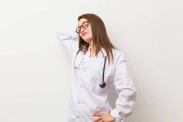 Jovem Médica Mulher Contra Uma Parede Branca Tocando Parte Trás — Fotografia de Stock