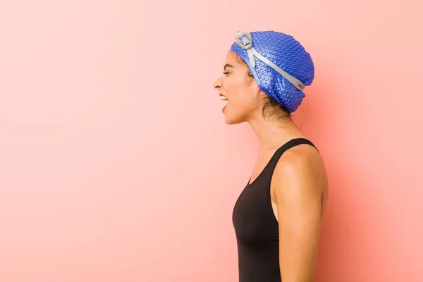 Young arab swimmer woman isolated shouting towards a copy space