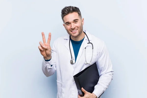 Caucasian Doctor Man Holding Folder Showing Victory Sign Smiling Broadly — Stock Photo, Image