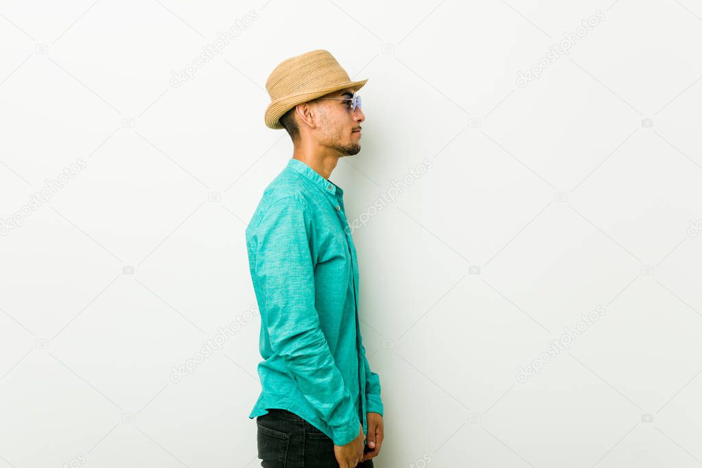 Young hispanic man wearing a summer clothes gazing left, sideways pose.