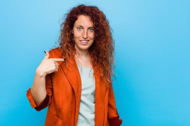 Genç redhead zarif kadın kişi bir gömlek kopyalama alanı, gurur ve kendinden emin elle işaret