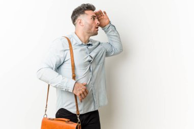 Genç yakışıklı iş adamı uzak alnına el tutarak bakıyor.