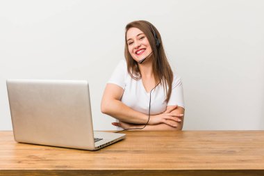 Genç telemarketer kadın gülüyor ve eğleniyor.