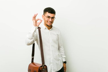 Genç İspanyol rahat iş adamı neşeli ve kendinden emin ok jest gösteren.