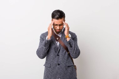 Beyaz bir duvara karşı genç iş filipinli adam tapınakdokunmadan ve baş ağrısı olan.