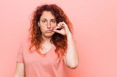 Dudaklarında parmakları bir sır tutan genç doğal ve otantik kızıl kadın.