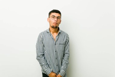 Genç İspanyol adam omuz silkiyor ve gözleri karışık açık.