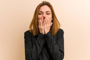 Kafkasyalı genç bir iş kadını bir şeye gülüyor, elleriyle ağzını kapatıyor..