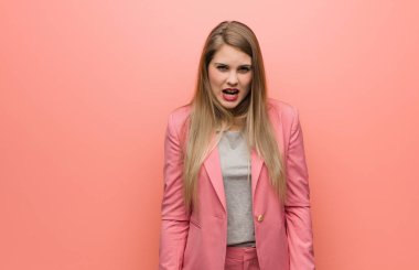 Young russian woman wearing pajama screaming very angry and aggressive