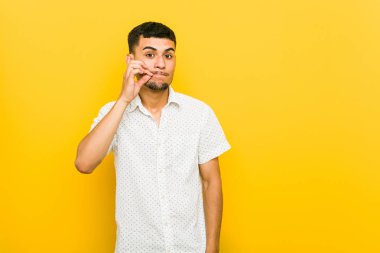 Dudaklar üzerinde parmaklar ile genç İspanyol adam bir sır tutmak.