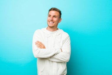 Genç kafkas spor adam çapraz kolları ile kendinden emin gülümseyen.