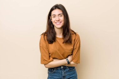 Genç esmer kadın bej arka plan gülerek karşı ve eğlenmek.