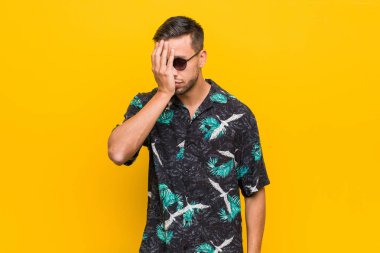 Genç filipinli adam bir şey unutmadan yazlık giysiler giyen, avuç içi ve kapanış gözleri ile alnına tokat.