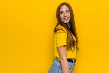 Genç kızıl kızıl saçlı kadın bir kenara gülümseyen, neşeli ve hoş görünüyor.