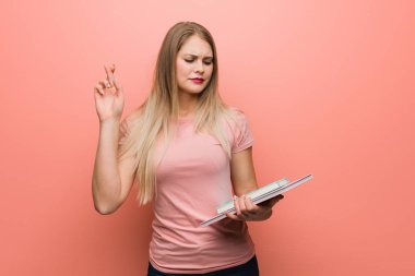 Genç güzel rus kız şans için parmaklarını geçiyor. Elinde kitap var..