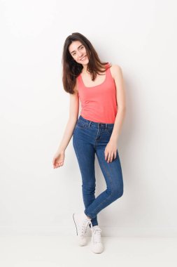 Beyaz bir arka planda ayakta Genç beyaz kadın