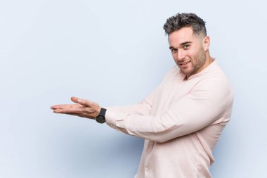 Genç yakışıklı serin adam bir avuç üzerinde bir kopya alanı tutan.