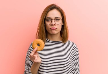 Elinde çörek tutan genç kadın, palmiye yağı konusunda endişeli.