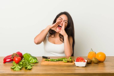 Genç kıvrımlı kadın ön heyecanlı bağırarak sağlıklı bir yemek hazırlanıyor.