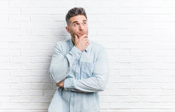 Young Handsome Man Bricks Wall Looking Sideways Doubtful Skeptical Expression — Stock Photo, Image