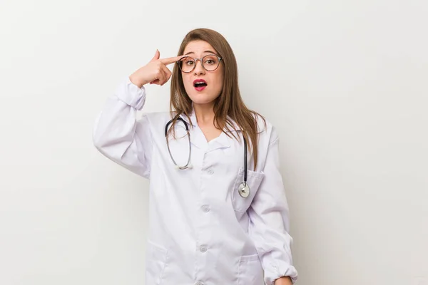 Jonge Dokter Vrouw Tegen Een Witte Muur Toont Een Teleurstelling — Stockfoto