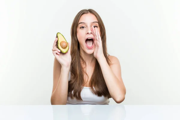 Joven Mujer Caucásica Sosteniendo Aguacate Gritando Emocionada Frente — Foto de Stock