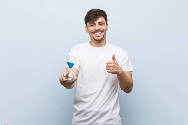 Jonge Spaanse Man Met Een Zandloper Glimlachend Het Verhogen Van — Stockfoto