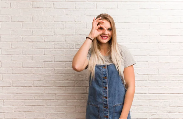Young russian hipster woman confident doing ok gesture on eye