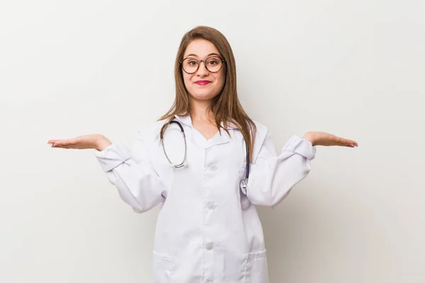 Jonge Dokter Vrouw Tegen Een Witte Muur Maakt Schaal Met — Stockfoto