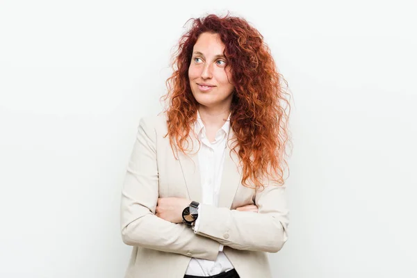 Young natural redhead business woman isolated against white background smiling confident with crossed arms.