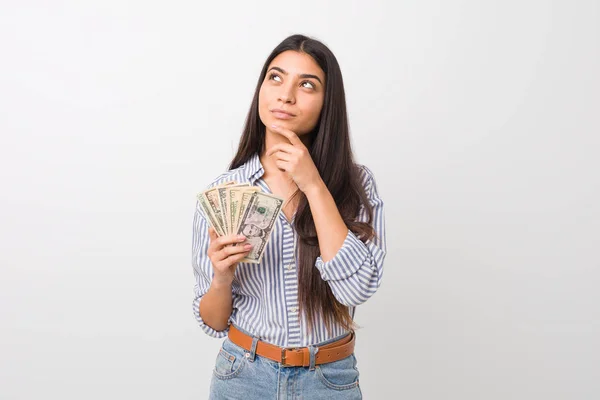 Young Arab Woman Holding Dollars Looking Sideways Doubtful Skeptical Expression — Stock Photo, Image