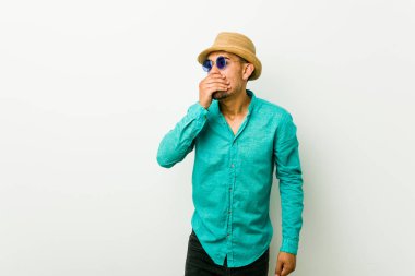 Genç İspanyol adam bir yaz giysileri giyen düşünceli el ile ağız kapsayan bir kopyasını alan arıyor.