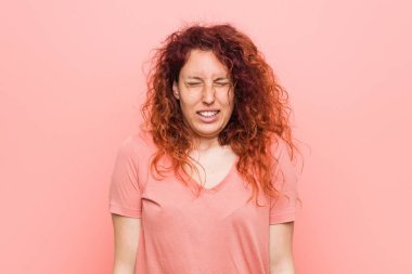 Genç doğal ve otantik kızıl saçlı kadın güler ve gözleri kapatır, rahat ve mutlu hissediyor.