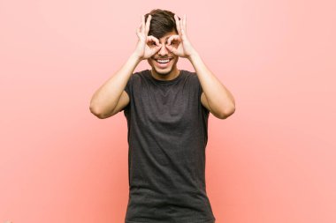 Genç İspanyol rahat adam gözleri üzerinde tamam işareti gösteren