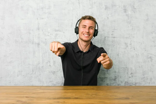 Mladý Kavkazský Muž Poslouchá Hudbu Sluchátky Veselé Úsměvy Ukazující Frontu — Stock fotografie