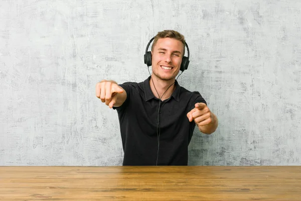 Unga Kaukasiska Man Lyssnar Musik Med Hörlurar Glada Leende Pekar — Stockfoto