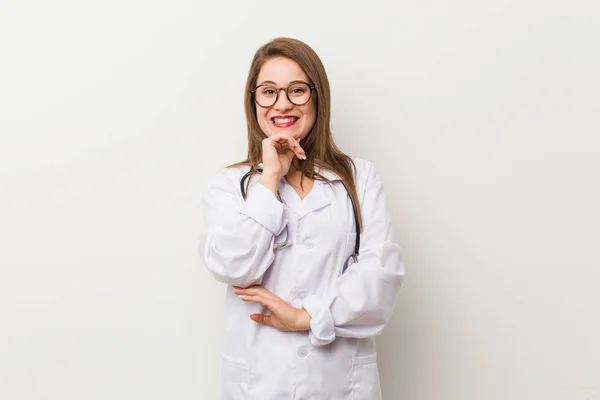 Jonge Dokter Vrouw Tegen Een Witte Muur Glimlachend Gelukkig Zelfverzekerd — Stockfoto