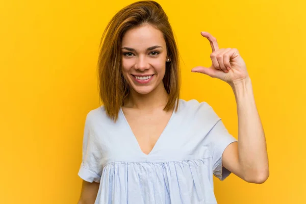 Jovem Mulher Bonita Segurando Algo Pouco Com Dedos Indicador Sorrindo — Fotografia de Stock