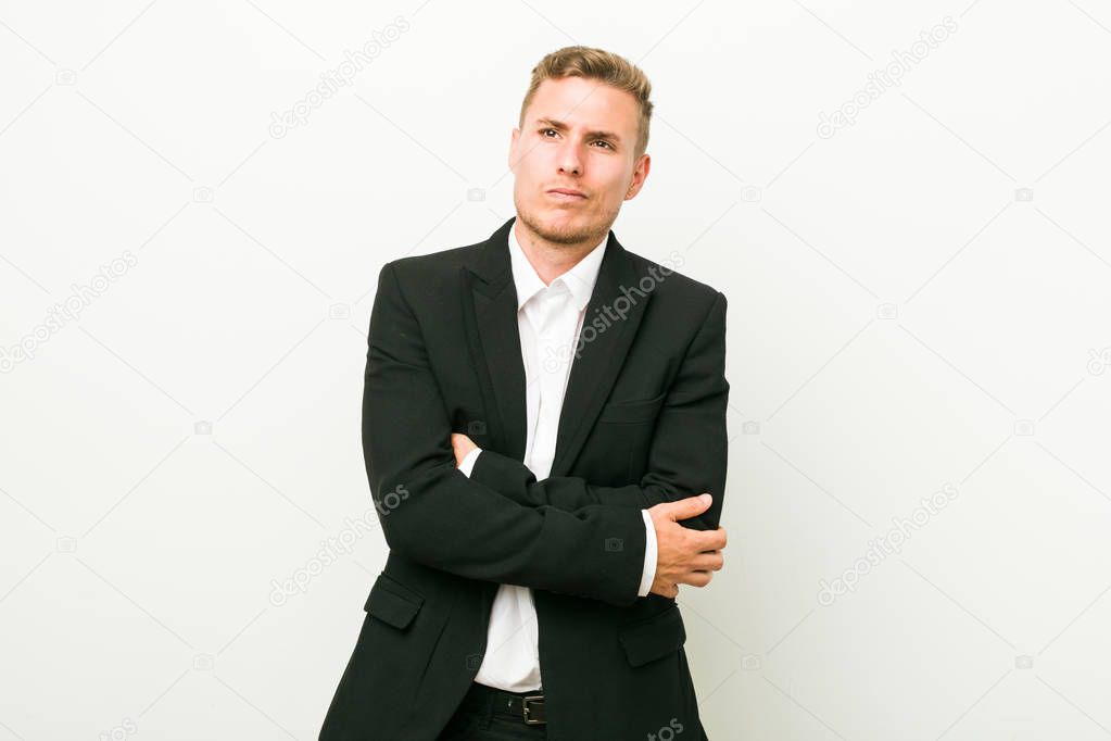 Young caucasian business man unhappy looking in camera with sarcastic expression.
