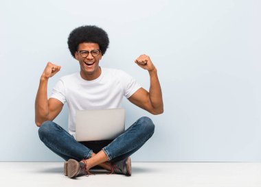 Teslim olmayan bir dizüstü bilgisayar ile katta oturan genç siyah adam