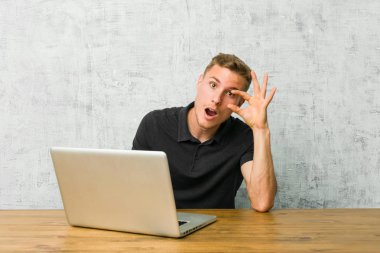 Bir masa üzerinde dizüstü bilgisayarıyla çalışan genç girişimci, başarı fırsatı bulmak için gözlerini açtı.