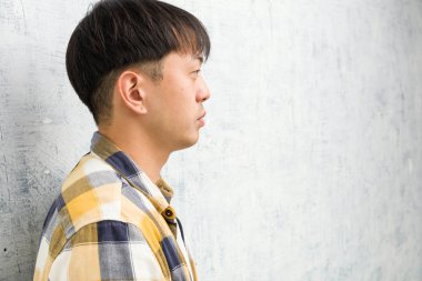 Young chinese man face closeup on the side looking to front clipart