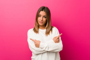 Bir duvar noktaları yanlara karşı Genç otantik karizmatik gerçek insanlar kadın, iki seçenek arasında seçim yapmaya çalışıyor.