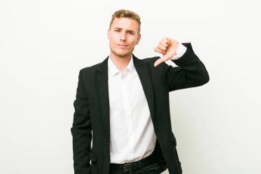 Genç beyaz iş adamı bir nefret jesti gösteren, başparmak aşağı. Anlaşmazlık kavramı.