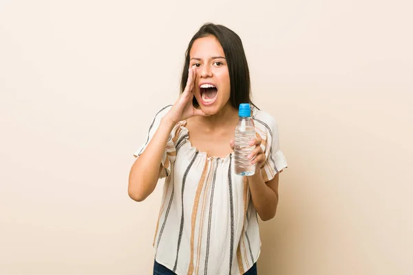 Junge Hispanische Frau Hält Eine Flasche Wasser Und Schreit Aufgeregt — Stockfoto