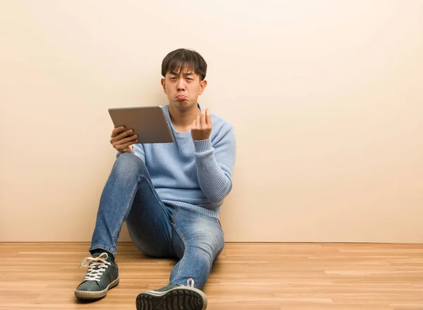 Jovem Chinês Sentado Usando Seu Tablet Fazendo Gesto Necessidade — Fotografia de Stock