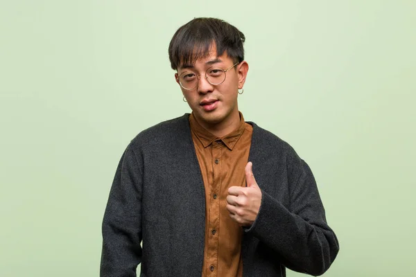 Mladý Čínský Muž Chladným Oblečením Zelené Pozadí — Stock fotografie