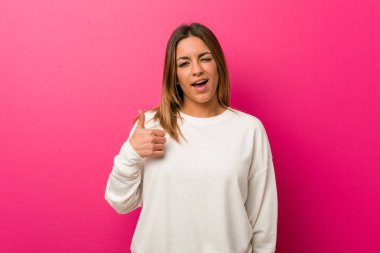 Genç otantik karizmatik gerçek insanlar kadın bir duvara karşı gülümseyerek ve başparmak yükselterek